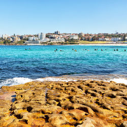 Scenic view of sea and buildings against clear sky