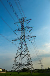 Low angle view of electricity pylon on field against sky