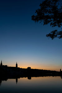 Scenic view of lake against clear blue sky during sunset