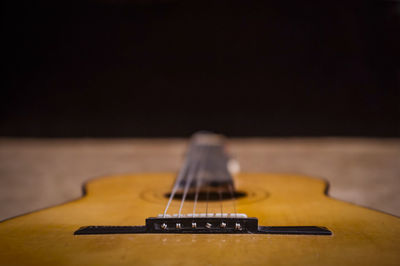 Surface level of acoustic guitar against black background