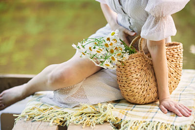 Midsection of woman sitting on bed