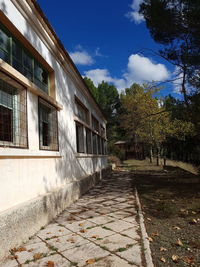 Footpath amidst buildings against sky