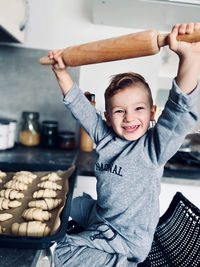 Portrait of boy holding rolling pin at home