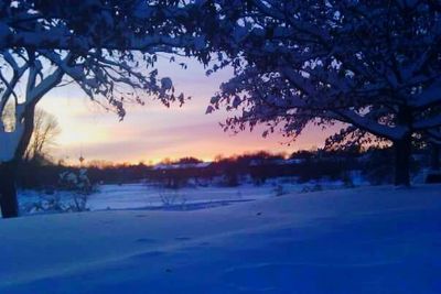 Snow covered landscape at sunset