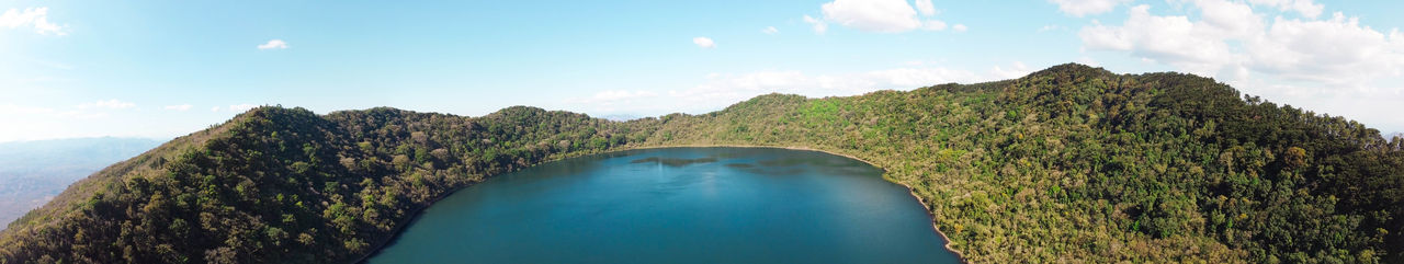 Panoramic view of green mountain against sky