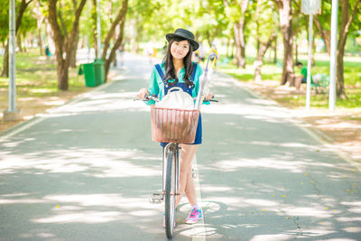 Portrait of woman riding bicycle on road