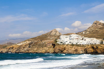 Scenic view of sea by buildings against sky