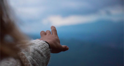 Close-up of hand against sea