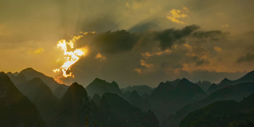 Scenic view of silhouette mountains against sky at sunset