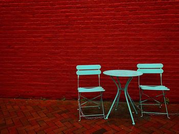 Empty chairs against red wall