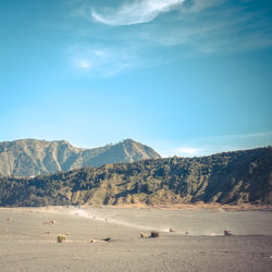 Scenic view of beach and mountains against sky