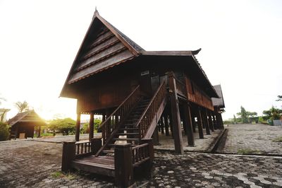 Exterior of house by building against clear sky