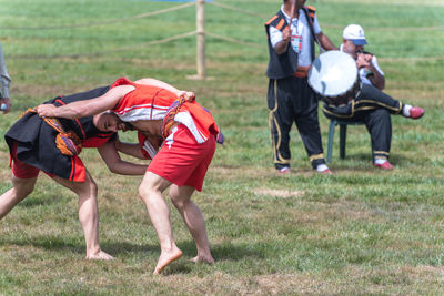 Rear view of people walking on grassland