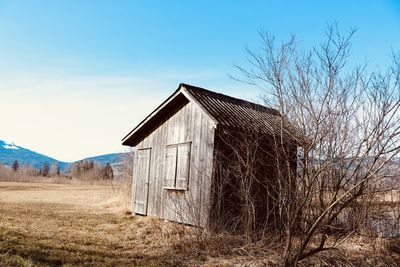 Abandoned house on field against sky