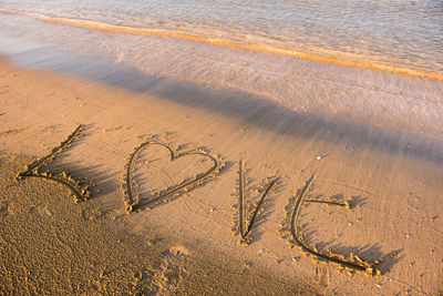 High angle view of love text on shore at beach