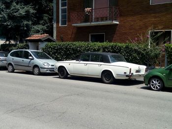 Car on street by buildings in city