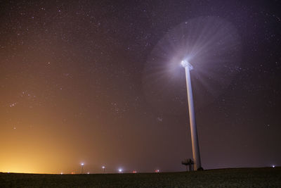 Low angle view of windmill against star field at night
