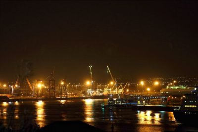 Illuminated commercial dock against sky at night