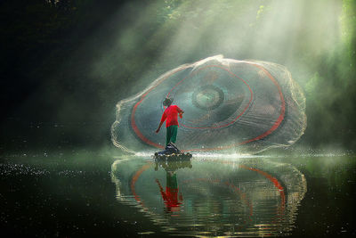 Full length of man with fishing net in lake