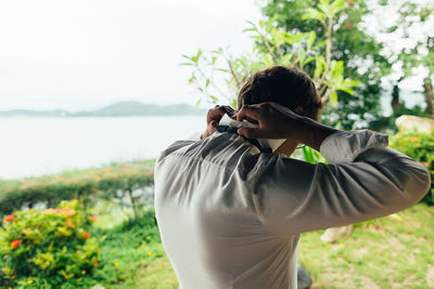 Rear view of man holding shirt collar