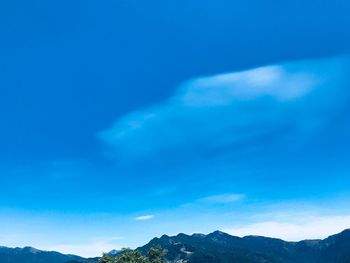 Low angle view of mountain range against blue sky