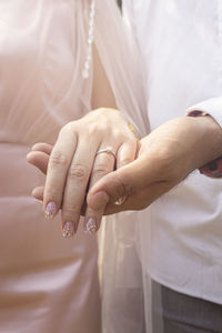 Midsection of couple holding hands