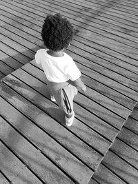 High angle view of kid standing on boardwalk