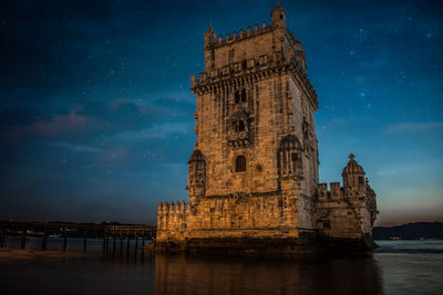 Torre de belem by river at night