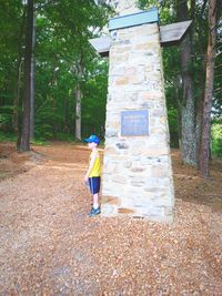 Full length of woman standing on tree trunk