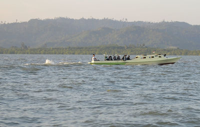 People in boat on sea against sky