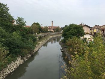 River amidst trees and buildings against sky