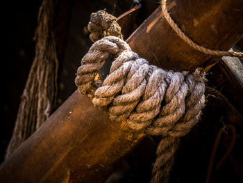 Close-up of rope tied to wooden post on boat