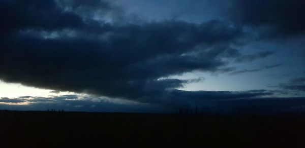 Storm clouds over silhouette landscape