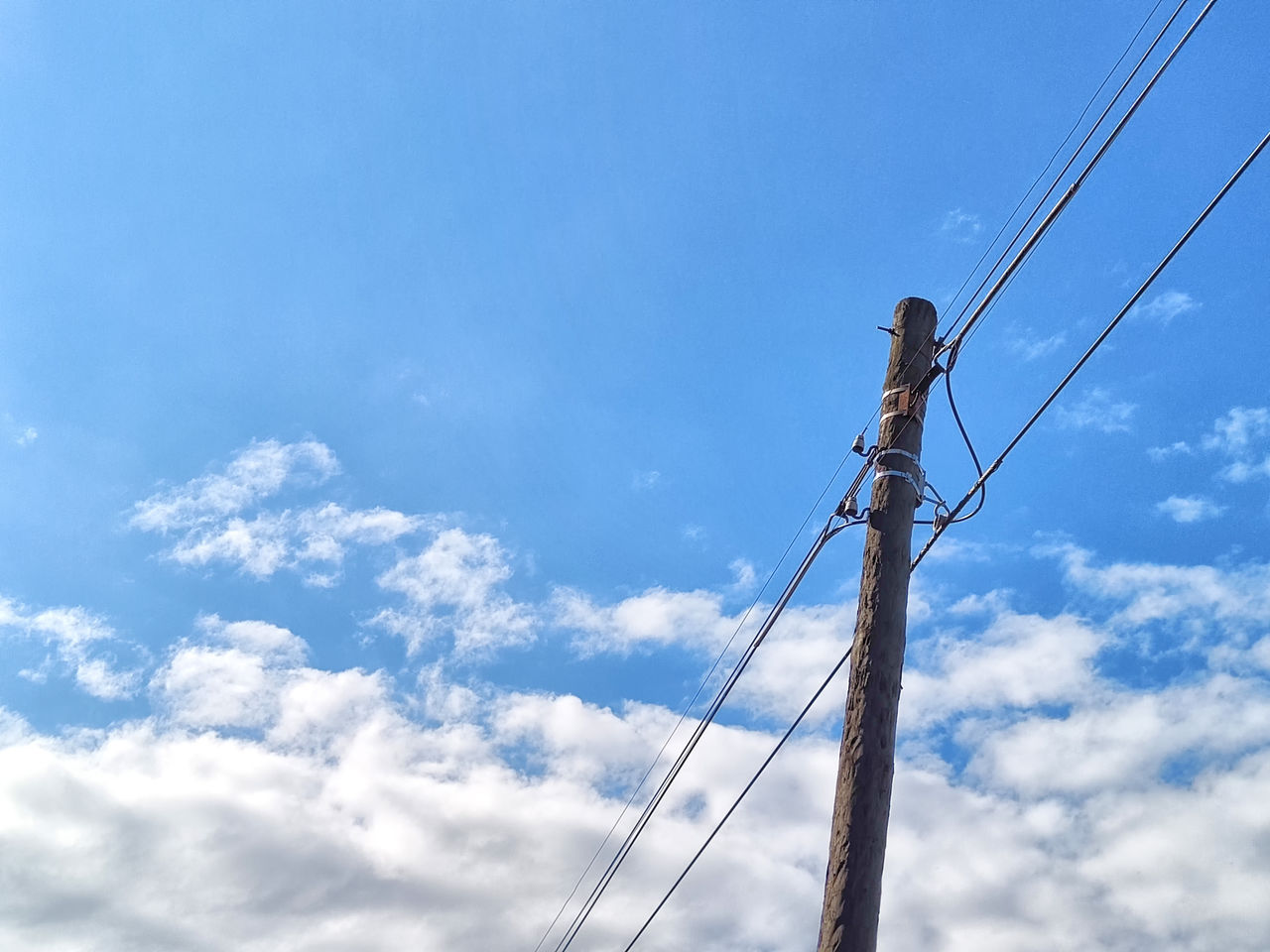 sky, cloud, blue, electricity, cable, low angle view, technology, overhead power line, nature, power supply, power generation, mast, day, wind, outdoors, power line, no people, telephone line, electricity pylon, telephone pole, pole, copy space, equipment