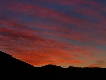 Low angle view of silhouette mountain against dramatic sky