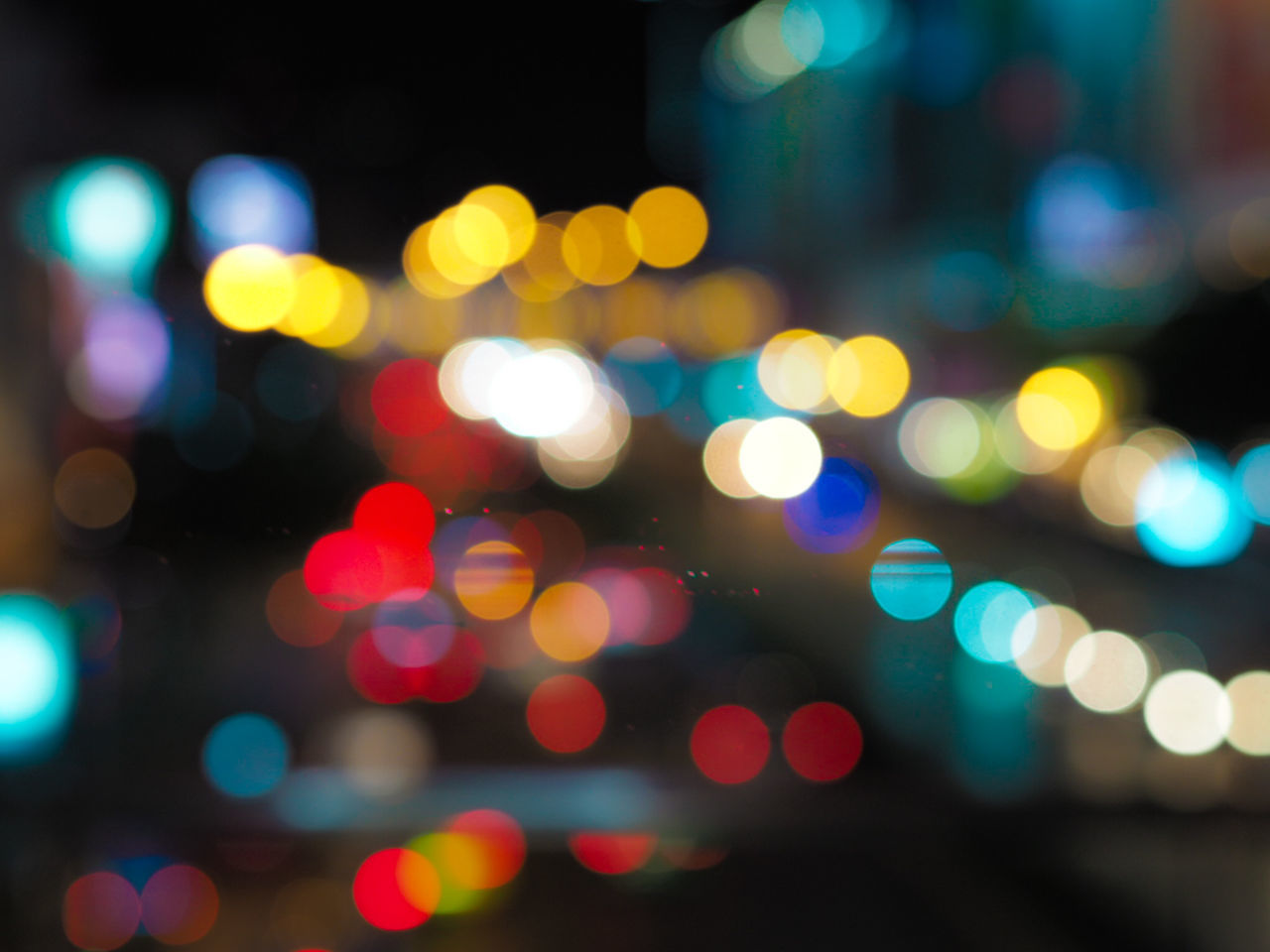 DEFOCUSED IMAGE OF ILLUMINATED LIGHTS ON STREET