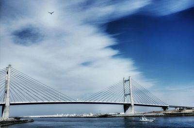 Low angle view of suspension bridge over river against sky