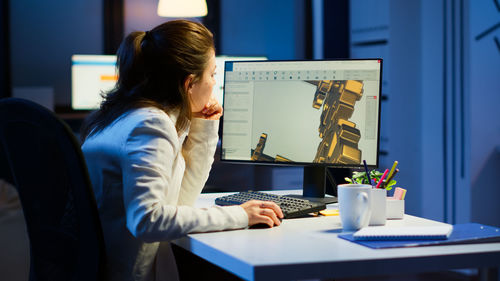 Side view of woman using laptop on table