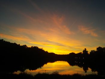 Scenic view of silhouette trees against orange sky