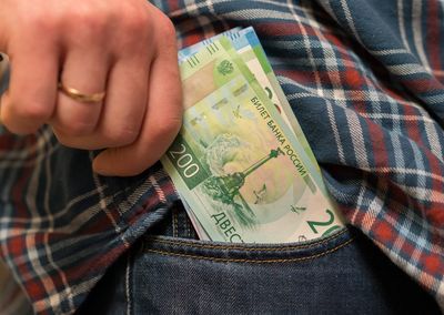 Midsection of man removing paper currency from pocket