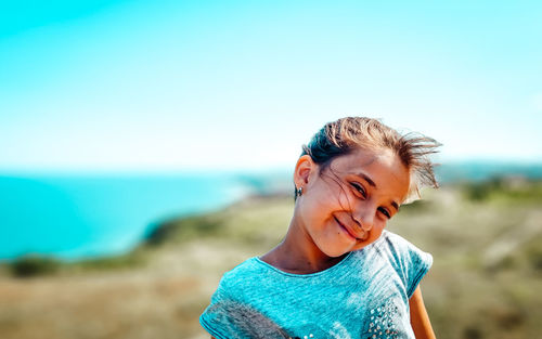 Portrait of smiling girl on beach against sky