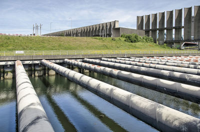 Water flowing on dam against sky