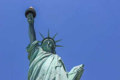 Low angle view of statue against blue sky