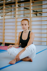 Young woman sitting in gym