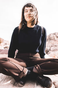 Young woman sitting on sand