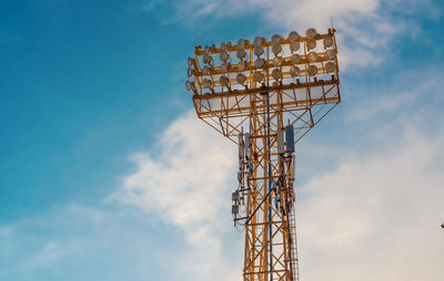 Stadium spotlight set on background of blue sky.