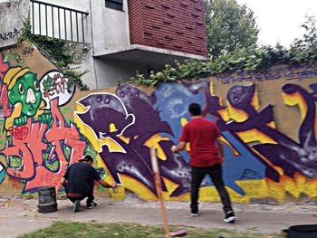 Full length of woman standing on graffiti wall