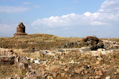 Built structure on field against cloudy sky