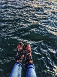 Low section of person standing in water
