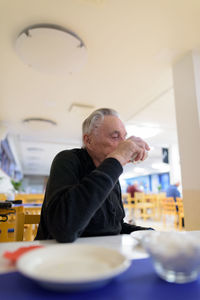 Portrait of a man sitting on table in restaurant